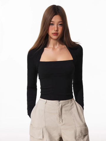 Woman wearing a black long-sleeve square neck top with a draped overlay, paired with beige cargo pants.