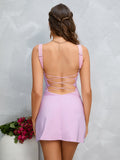 Back view of a woman in a lavender crepe sheath mini dress with an open back and criss-cross straps
