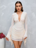 Model posing in a cream ruched bodycon dress with long flared sleeves