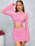 Woman wearing a pink sparkle mesh crop top with bell sleeves and a matching mini skirt, posing from the front.