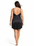 Back view of a woman in a black satin slip dress with lace detailing.