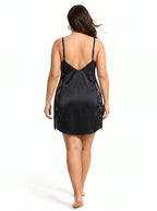 Back view of a woman in a black satin slip dress with lace detailing.