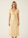 Woman wearing a yellow floral print midi dress with short puff sleeves and a tie-front v-neckline.