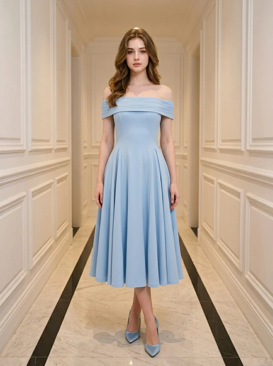 Woman wearing a light blue off-the-shoulder midi dress with a fitted bodice and full skirt, standing in a hallway.