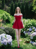 Woman in a red off-the-shoulder dress walking in a floral garden