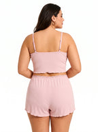 Back view of a plus-size woman in a pink ribbed knit pajama set