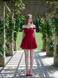Woman in a red off-the-shoulder dress walking through an outdoor pergola