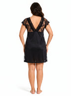 Woman wearing a black lace-trimmed chemise from the back.