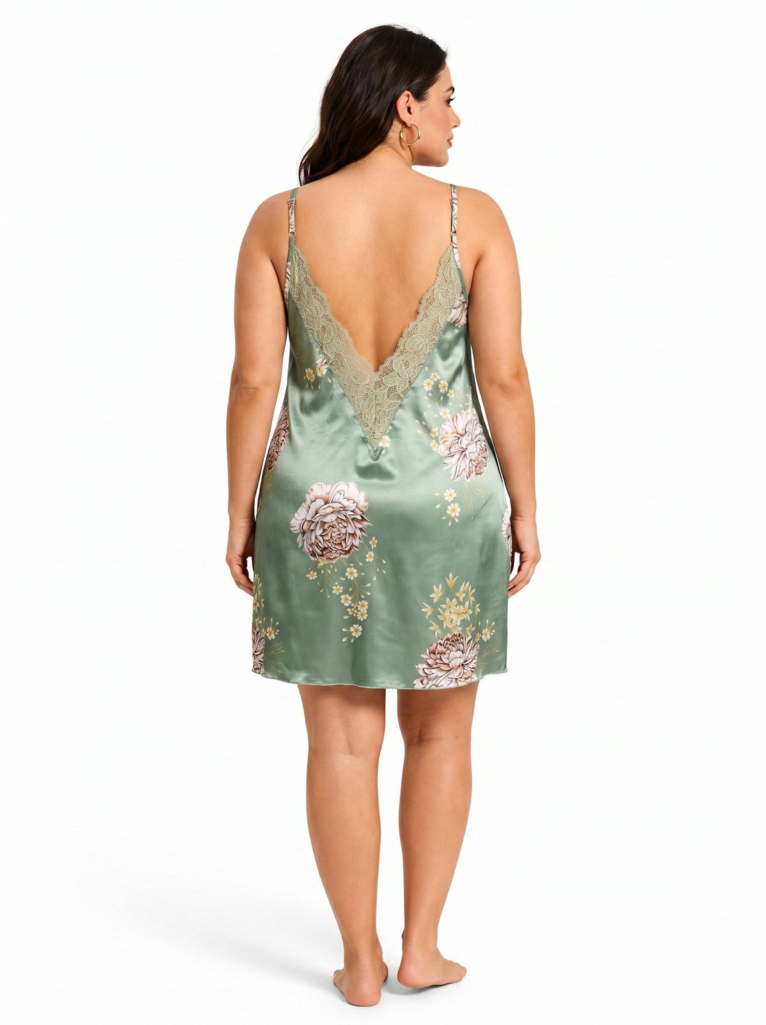 Woman wearing a green satin slip dress with a floral print and lace trim