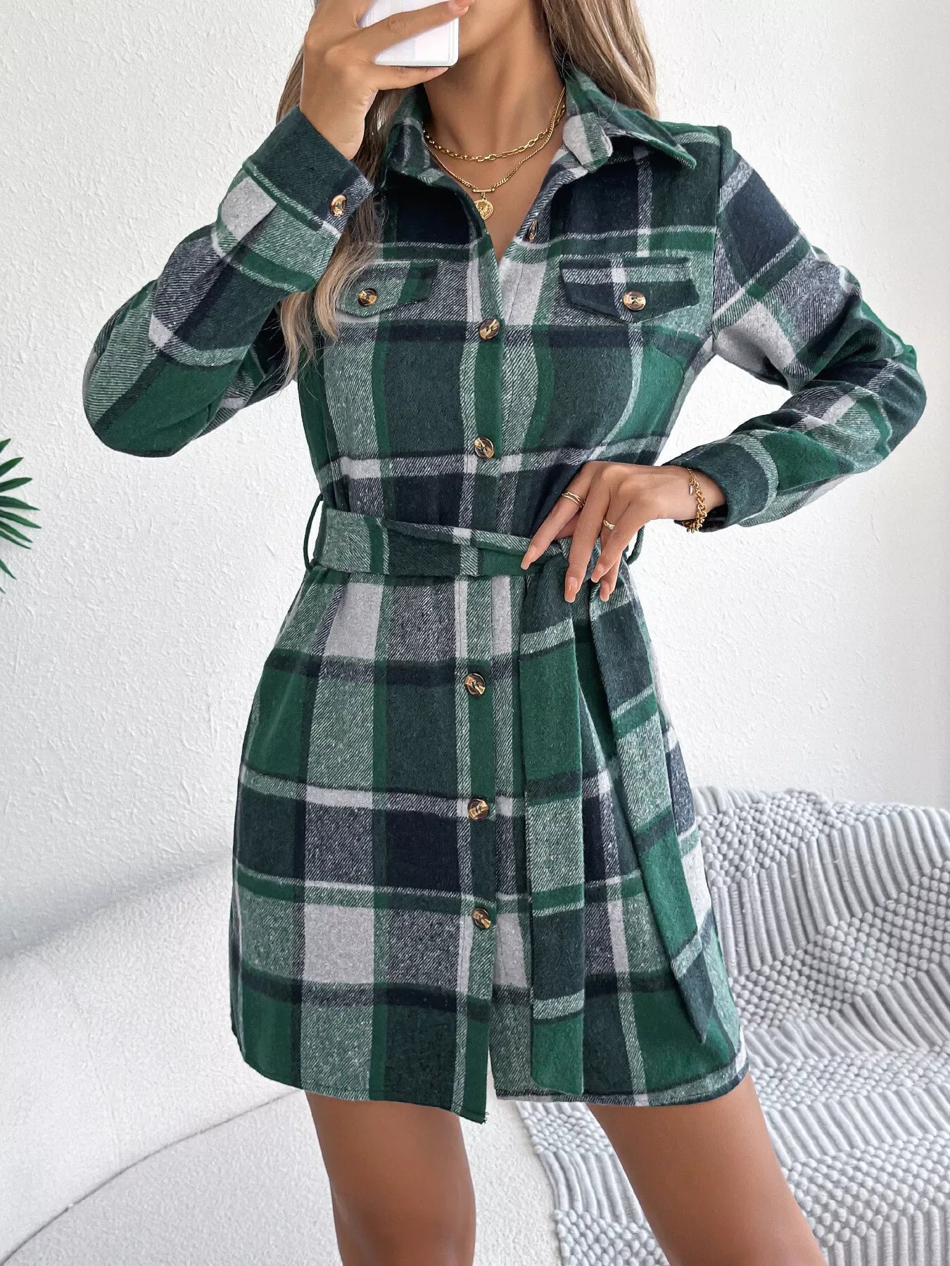Close-up of the green plaid flannel shirt dress, highlighting the tie waist and collar.