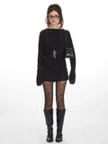 Model wearing a black long-sleeved top and star-print tights from the front.