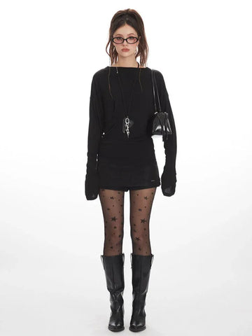 Model wearing a black long-sleeved top and star-print tights from the front.