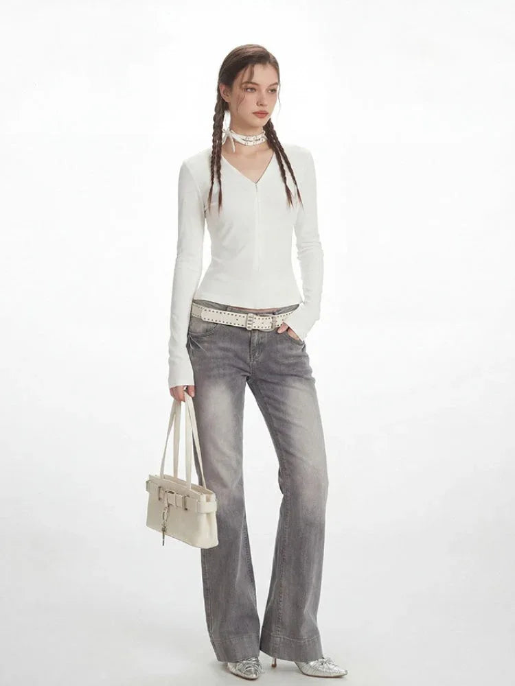 Full-length view of a woman in a white long-sleeve top and grey jeans