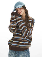 Woman in a striped knit sweater resting her head on her arm.