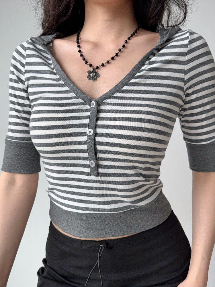 Detail shot of the neckline and buttons on a striped cropped knit top