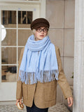 woman wearing a light blue scarf with fringe detail around her neck