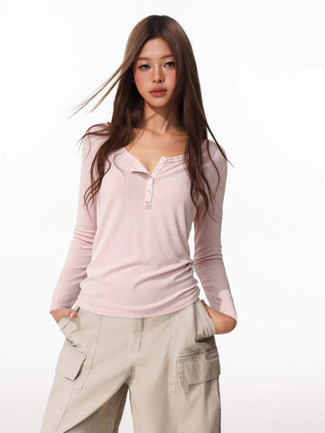 Woman wearing a pink long-sleeve henley shirt and beige cargo pants