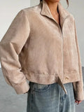 Close-up of the front of a beige corduroy cropped jacket on a woman.