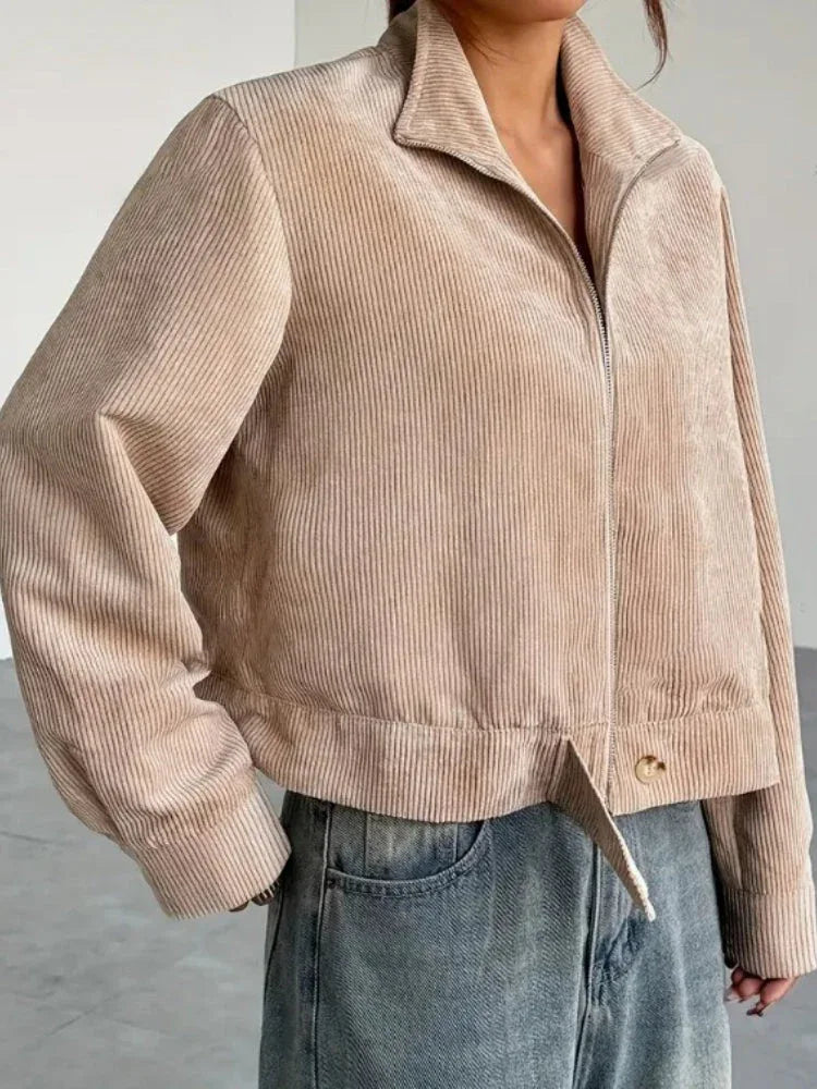 Close-up of the front of a beige corduroy cropped jacket on a woman.