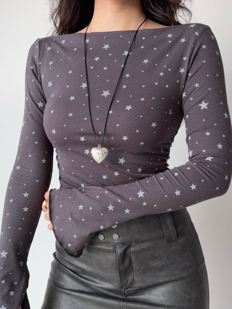 Side profile of a woman wearing a grey long-sleeve top with a subtle star pattern.