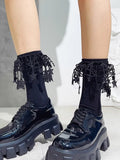 Detail of black ankle socks adorned with decorative lace and star motifs.