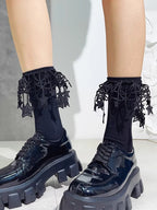Detail of black ankle socks adorned with decorative lace and star motifs.