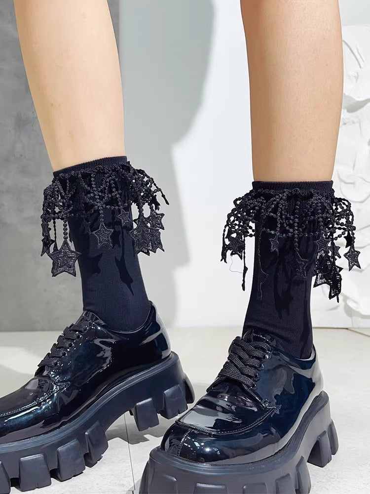Detail of black ankle socks adorned with decorative lace and star motifs.