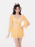 Woman wearing a yellow tie-dye mini dress with long puff sleeves and ruffled trim.