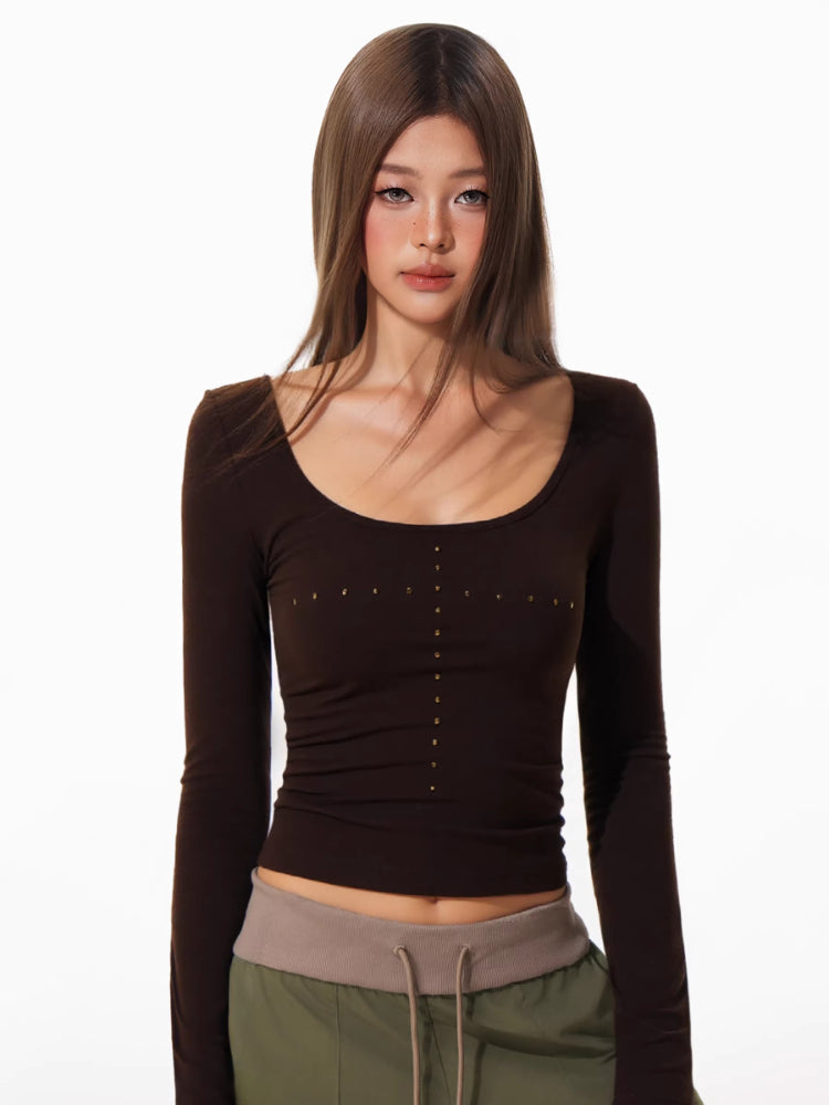Close-up of the embellished scoop neckline on the brown long-sleeve top