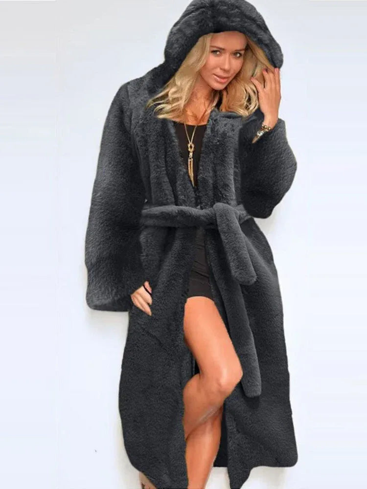 Woman wearing a long grey hooded faux fur coat with a belt Main image