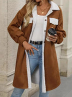 Close-up of the button-down front of a brown fleece jacket with contrasting sherpa trim.
