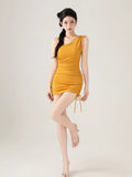 Full body shot of a woman in a yellow one-shoulder ribbed knit bodysuit with adjustable drawstring details