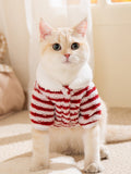 Cat wearing a red and white striped fleece pet jacket with a white collar.