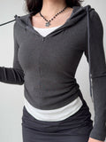 Detail shot of the ruched side seam on a charcoal grey hooded zip-up top.