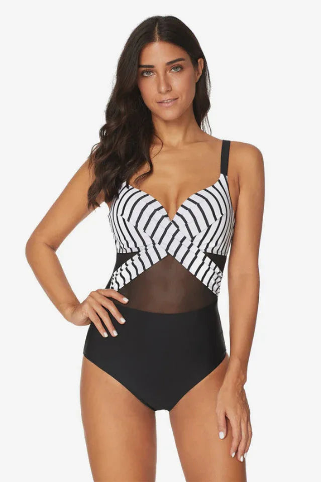 Woman wearing a black and white striped one-piece swimsuit with mesh accents