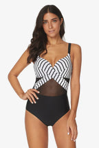 Woman wearing a black and white striped one-piece swimsuit with mesh accents