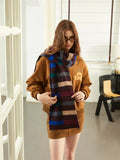 Woman adjusting a striped scarf over a brown bomber jacket