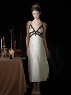 Full body shot of a woman in a white satin slip dress with lace accents