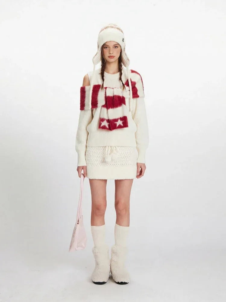 Model wearing a cream knit sweater with off-the-shoulder detail and a matching knit mini skirt.