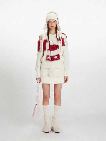 Model wearing a cream knit sweater with off-the-shoulder detail and a matching knit mini skirt.