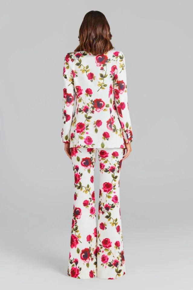 Rear view of a woman in a white floral print suit.