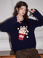 Close-up of a woman's torso showing the popcorn graphic on a navy blue sweater
