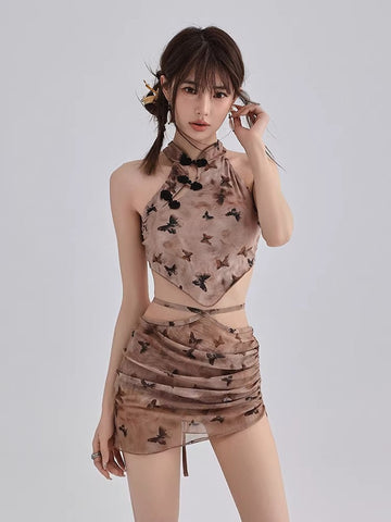 Woman wearing a brown sheer mesh two-piece set with a butterfly print, featuring a halter crop top and a mini skirt.