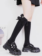 Styling example of black socks with loafers and a decorative bow.
