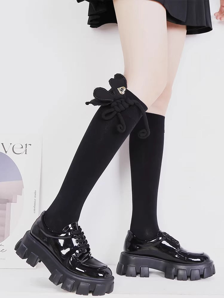 Styling example of black socks with loafers and a decorative bow.