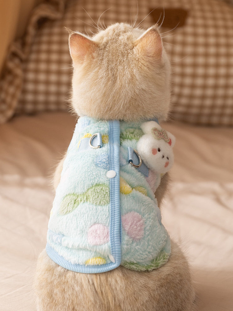 Back view of cat wearing light blue fleece vest with decorative bear applique
