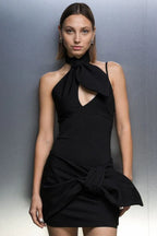 Front view of a fitted black mini dress with a cut-out and knotted skirt accent