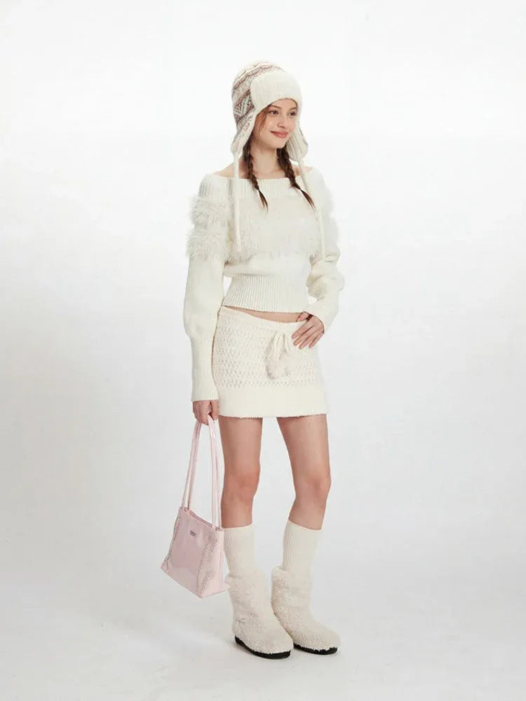 Woman wearing a white off-the-shoulder knit sweater with fuzzy trim and a matching white knit mini skirt with a drawstring waist.