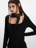 Detailed view of the black long-sleeve ribbed top with a square neckline and a black scarf tied around the neck.
