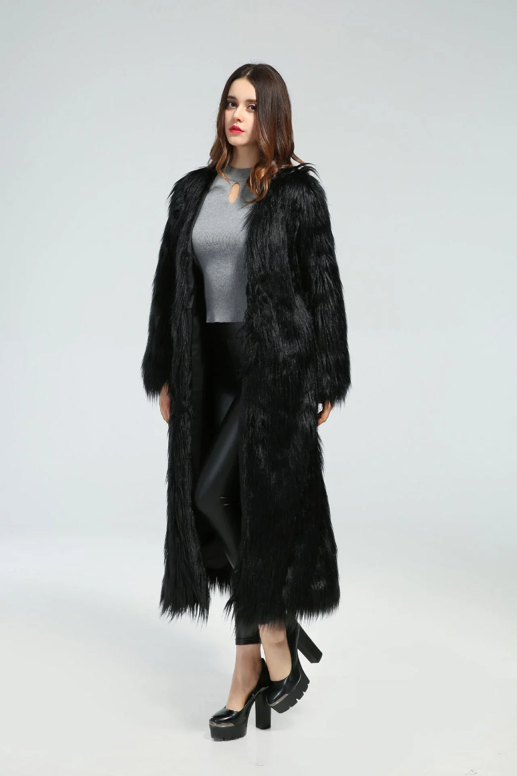 Full-length view of a woman in a black longline faux fur coat.